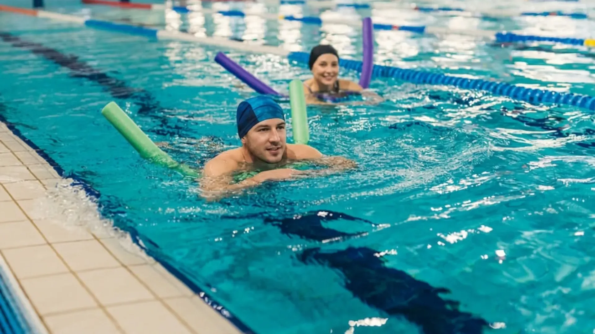 Erwachsene im Schwimmkurs mit Poolnudeln