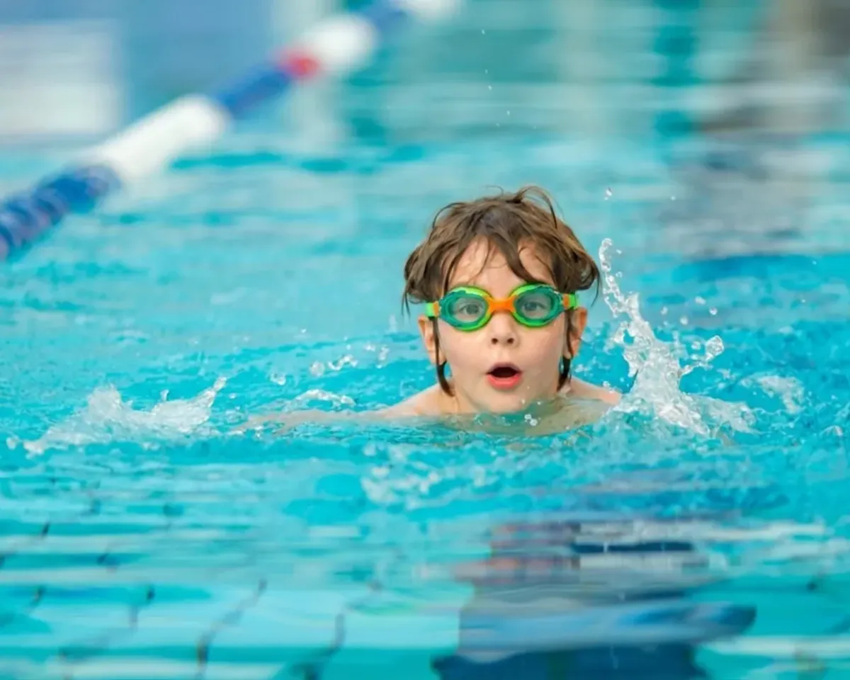 Kind trainiert längere Schwimmphasen im Wasser