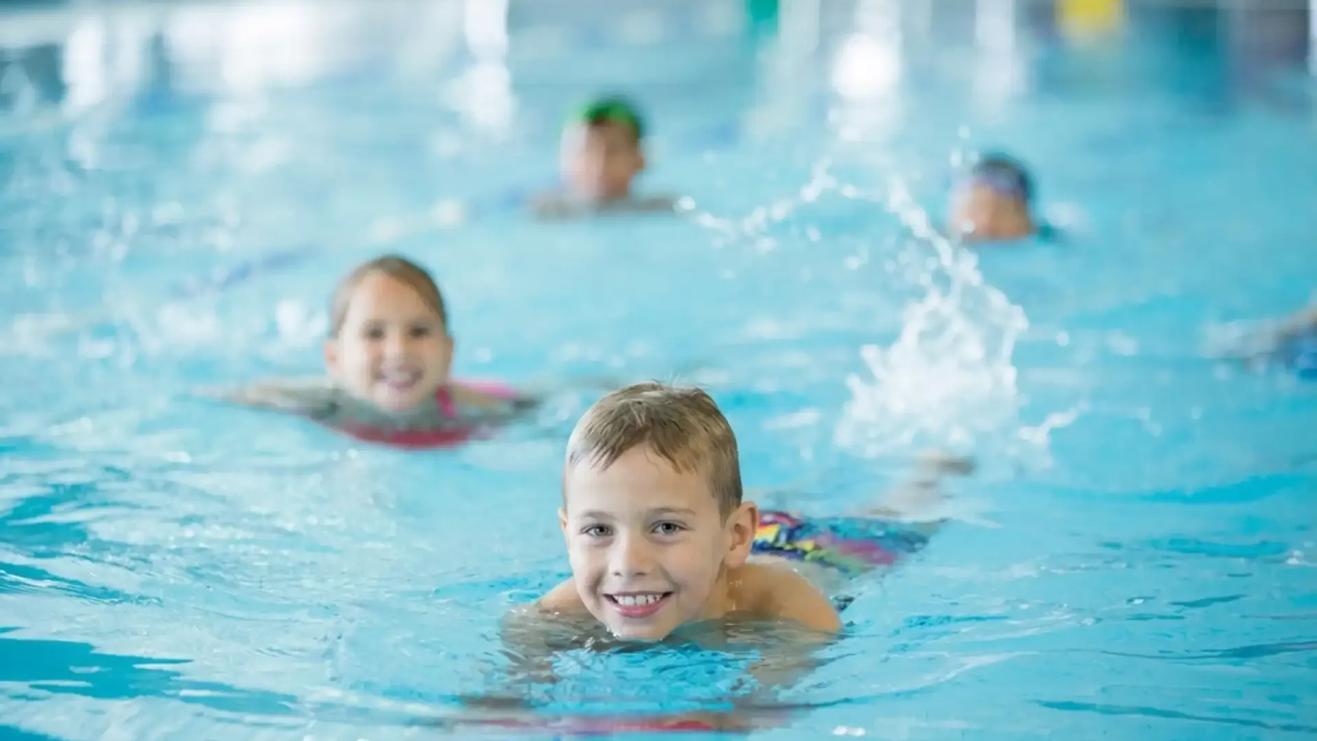 Kinder beim Schwimmkurs im Wasser
